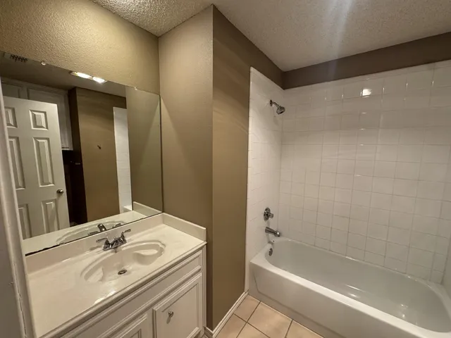 a bathroom with a tub sink and mirror