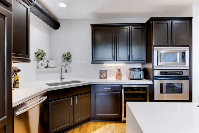 a kitchen with stainless steel appliances granite countertop a sink and a stove