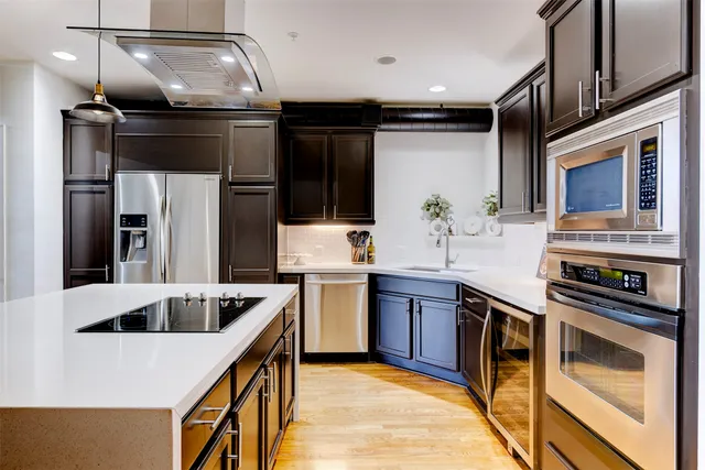 a kitchen with stainless steel appliances granite countertop a sink a stove and a refrigerator