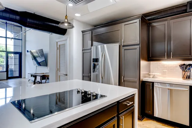a kitchen with stainless steel appliances granite countertop a sink and a refrigerator