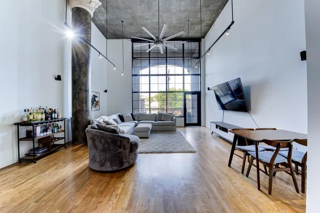 a living room with furniture a flat screen tv and a wooden floor