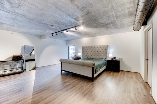 a bedroom with a bed and wooden floor