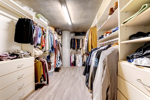 a view of walk in closet with clothes and shoes