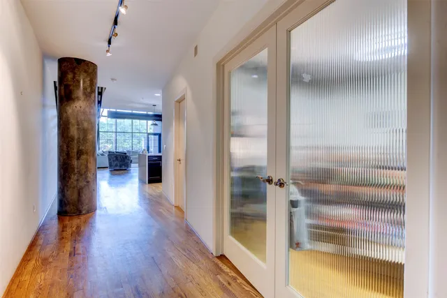 a view of hallway with livingroom and wooden floor
