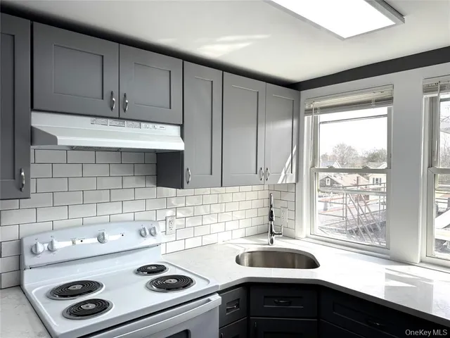a kitchen with a sink a stove and cabinets