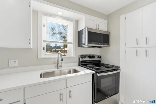 a kitchen with cabinets stainless steel appliances and a sink