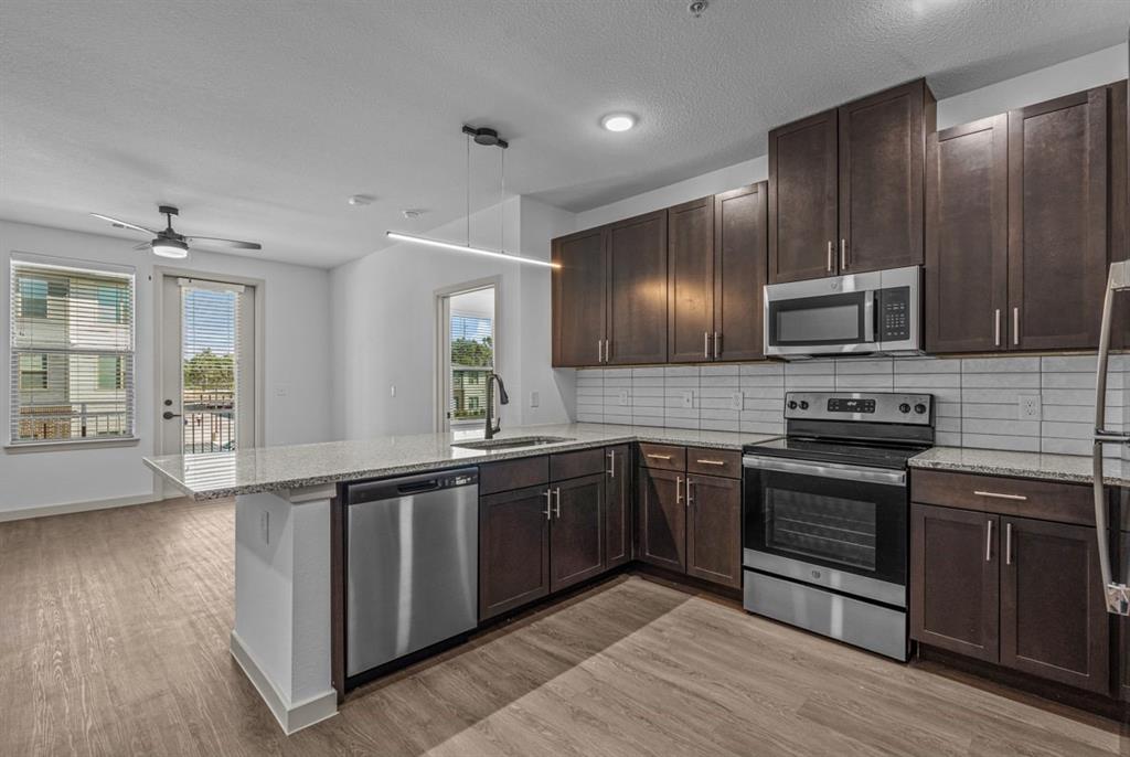 3120 East Park Row Drive, Unit 4312 Arlington, TX 76010 - Photo 4 of 11 a large kitchen with wooden cabinets and stainless steel appliances
