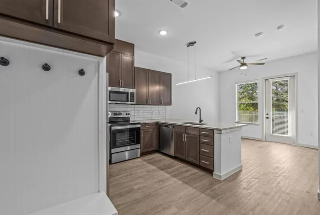 a large kitchen with stainless steel appliances granite countertop a stove and a refrigerator