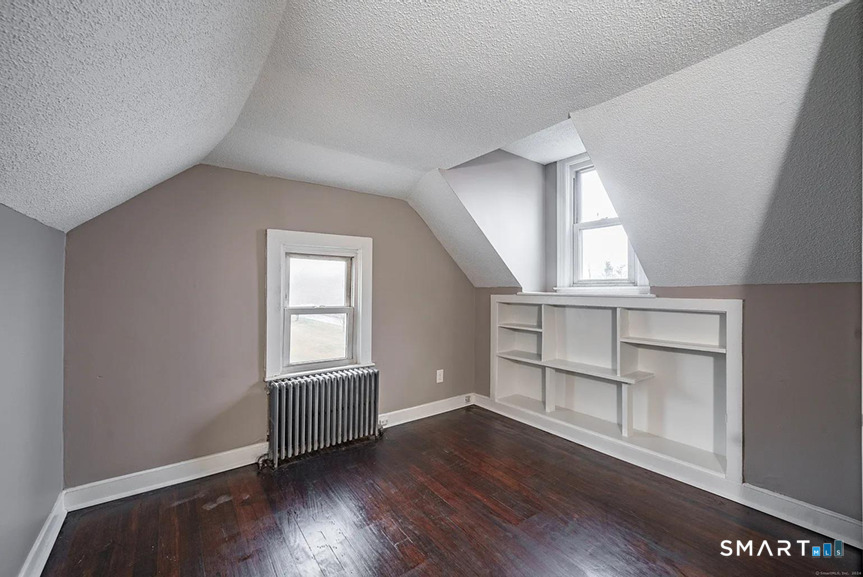 73 Silver Street Middletown, CT 06457 - Photo 29 of 30 an empty room with wooden floor cabinet and windows