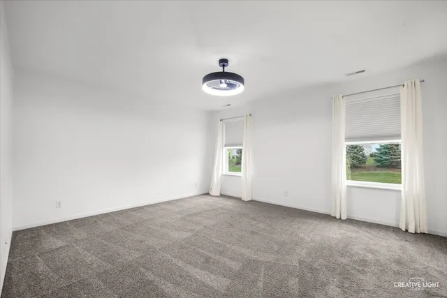 an empty room with windows and closet