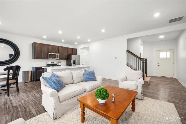 a living room with furniture and a view of kitchen