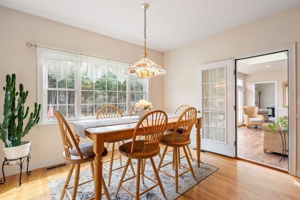 5 Rolling Meadow Drive Millis, MA 02054 - Photo 17 of 42 a dining room with furniture potted plants and wooden floor
