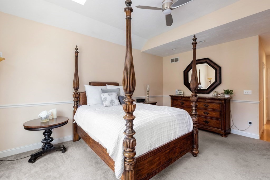 5 Rolling Meadow Drive Millis, MA 02054 - Photo 22 of 42 a bedroom with a bed a mirror on dresser and a chandelier