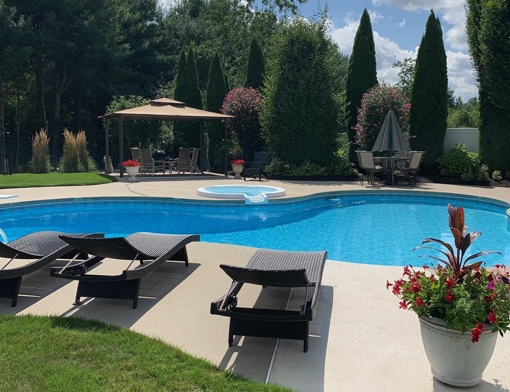 5 Rolling Meadow Drive Millis, MA 02054 - Photo 41 of 42 a view of a swimming pool with a table and chairs under an umbrella