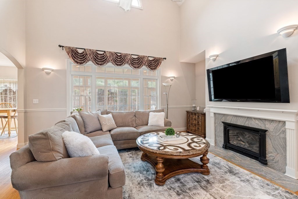 5 Rolling Meadow Drive Millis, MA 02054 - Photo 10 of 42 a living room with furniture a flat screen tv and a fireplace