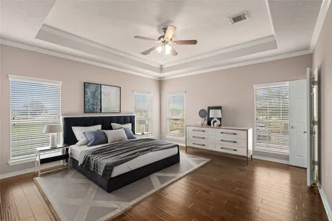 an empty room with wooden floor closet fan and windows