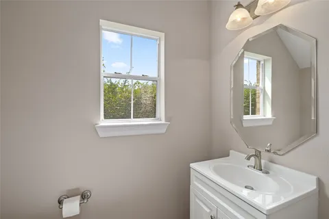 a bathroom with a sink mirror and window
