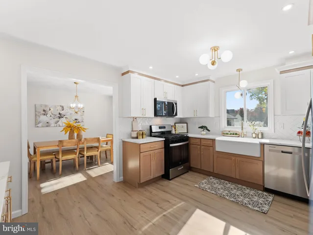 a large kitchen with kitchen island a sink table and chairs