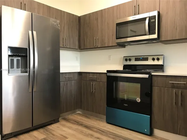 a kitchen with stainless steel appliances white cabinets and a refrigerator