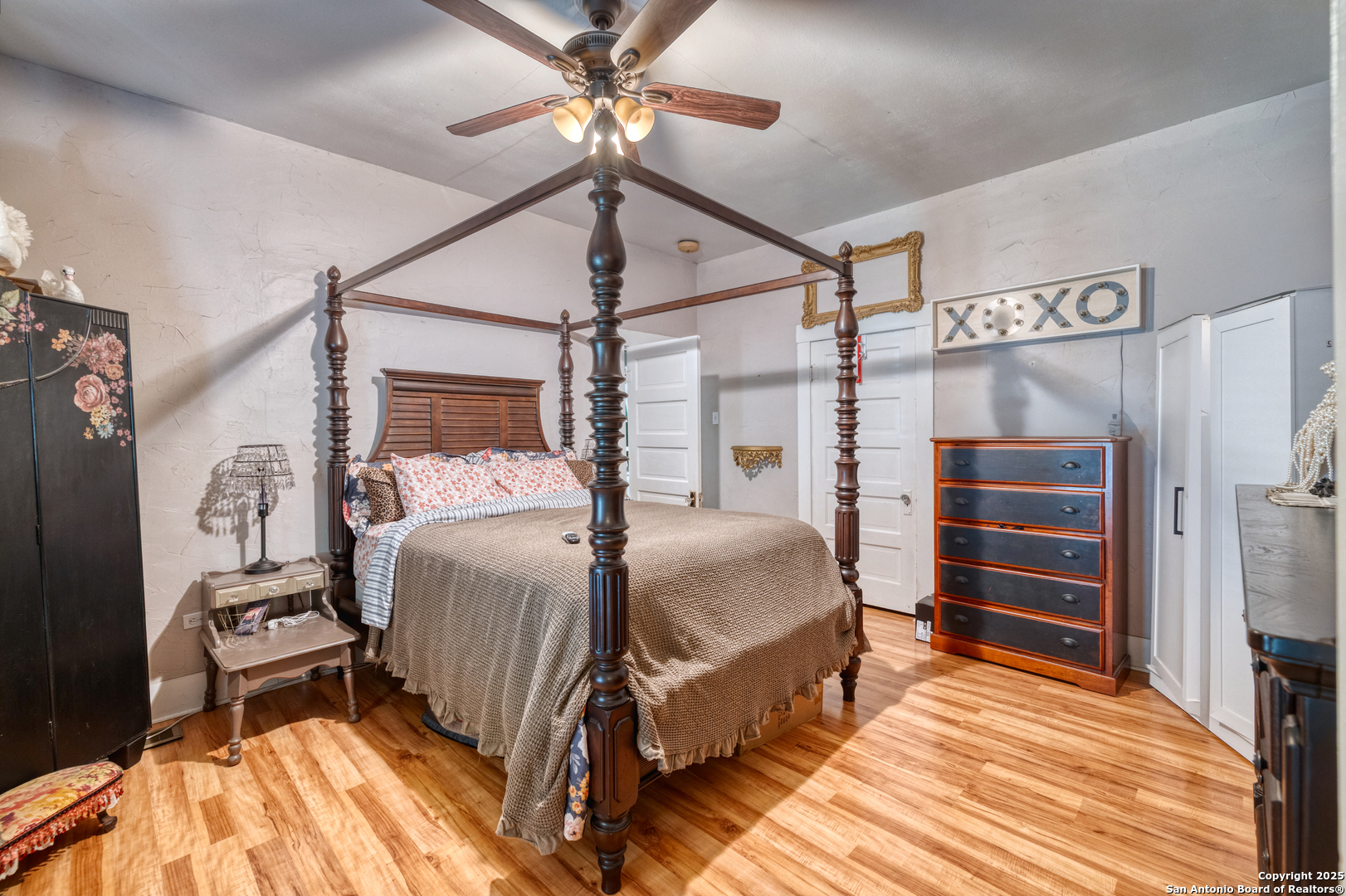 518 North Getty Street Uvalde, TX 78801 - Photo 11 of 31 a bedroom with a bed a dresser and a chandelier