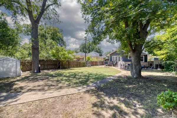a view of a small house with wooden fence