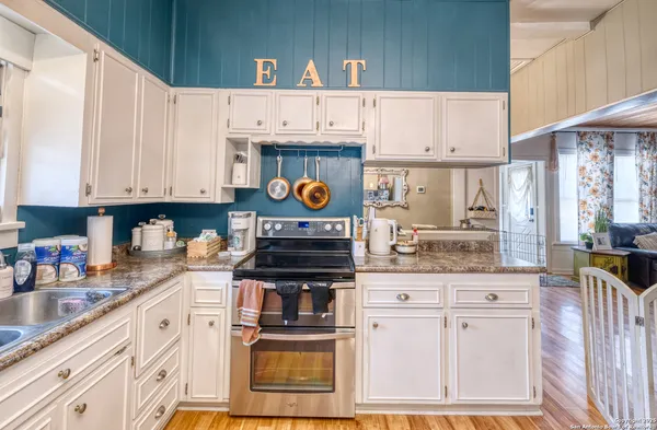 a kitchen with stainless steel appliances granite countertop a stove a sink and a white cabinets