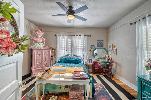 a bedroom with a bed a dresser and a chandelier