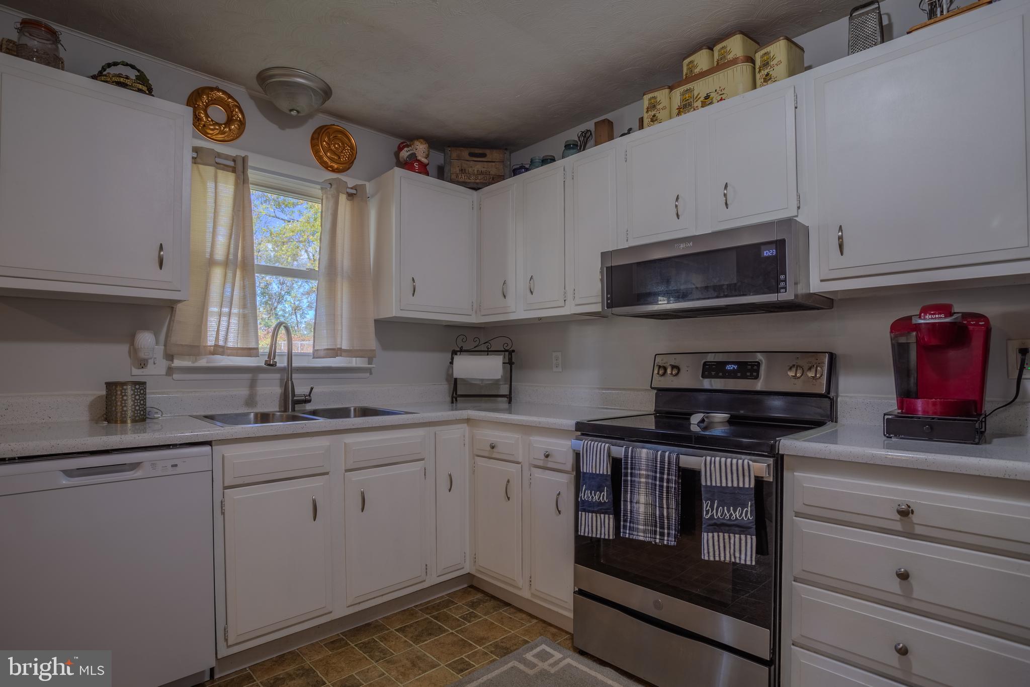 106 McDonald Street Ranson, WV 25438 - Photo 11 of 27 a kitchen with stainless steel appliances granite countertop a sink a stove a microwave and cabinets