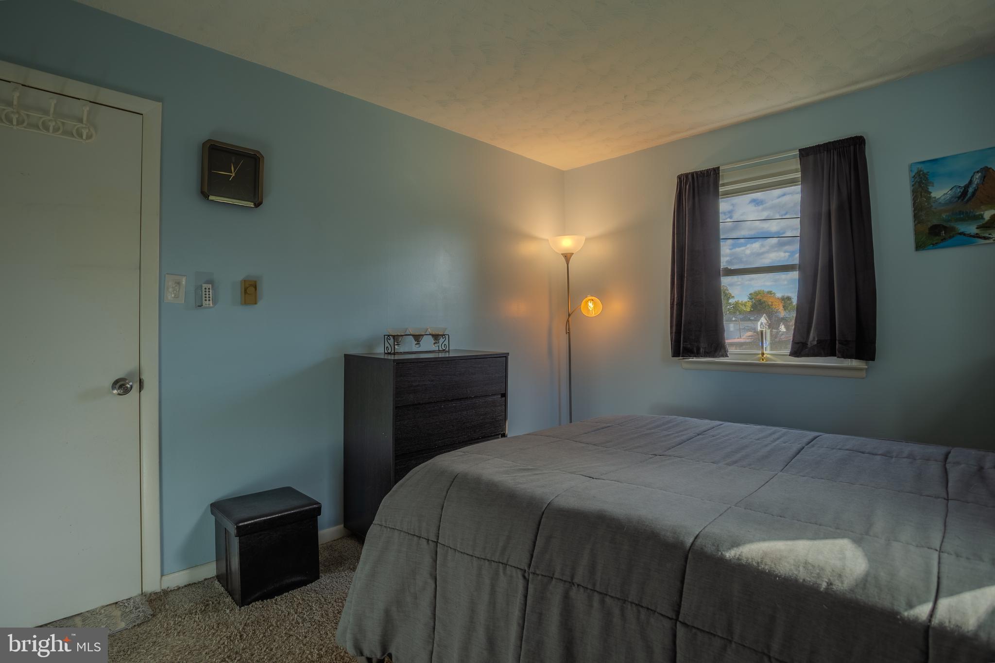 106 McDonald Street Ranson, WV 25438 - Photo 17 of 27 a bedroom with a bed and a lamp on dresser