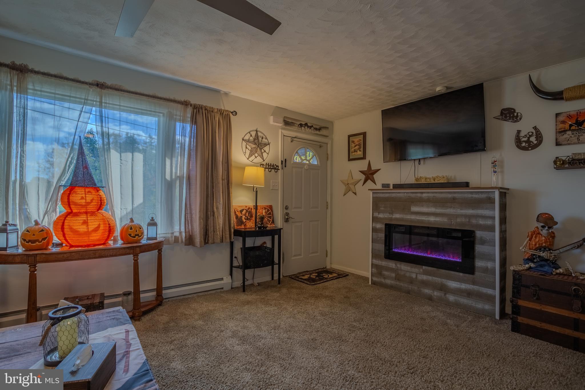 106 McDonald Street Ranson, WV 25438 - Photo 7 of 27 a living room with furniture a flat screen tv and a fireplace