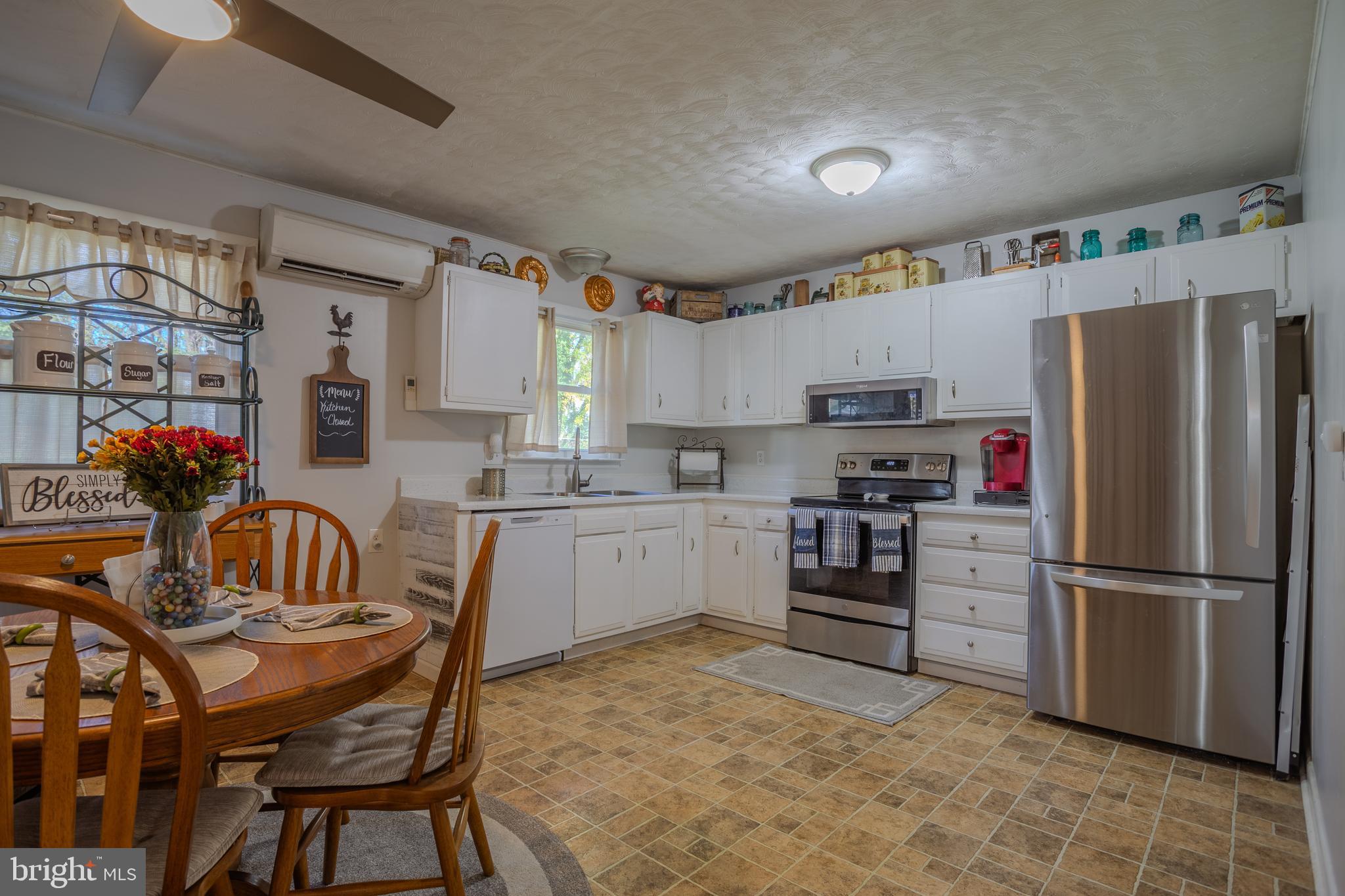 106 McDonald Street Ranson, WV 25438 - Photo 9 of 27 a kitchen with stainless steel appliances granite countertop a refrigerator a stove a sink dishwasher a dining table and chairs with wooden floor