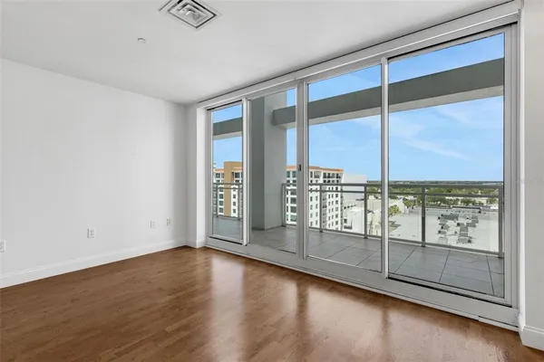 a view of an empty room with wooden floor