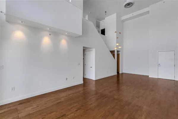 a view of an empty room with wooden floor