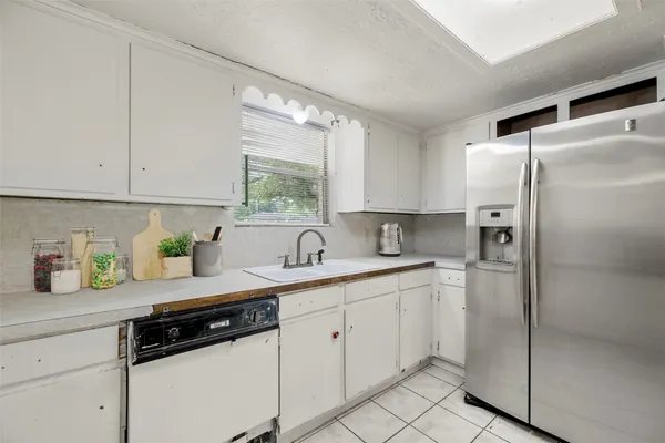 a kitchen with a sink a refrigerator and window