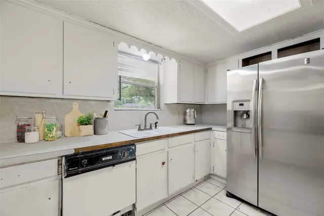 a kitchen with a sink a refrigerator and window