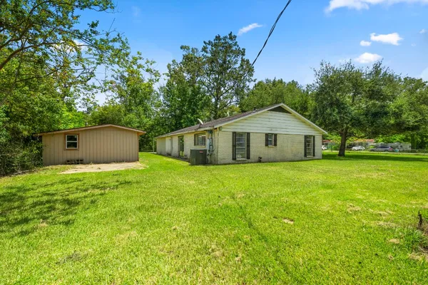 a view of a house with a yard and tree