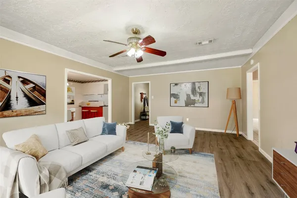 a living room with furniture and a wooden floor