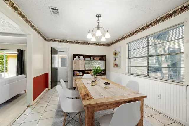 a very nice looking dining room with a large window and chandelier