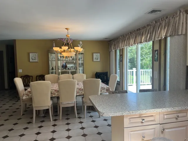 a dining room with furniture a chandelier and window