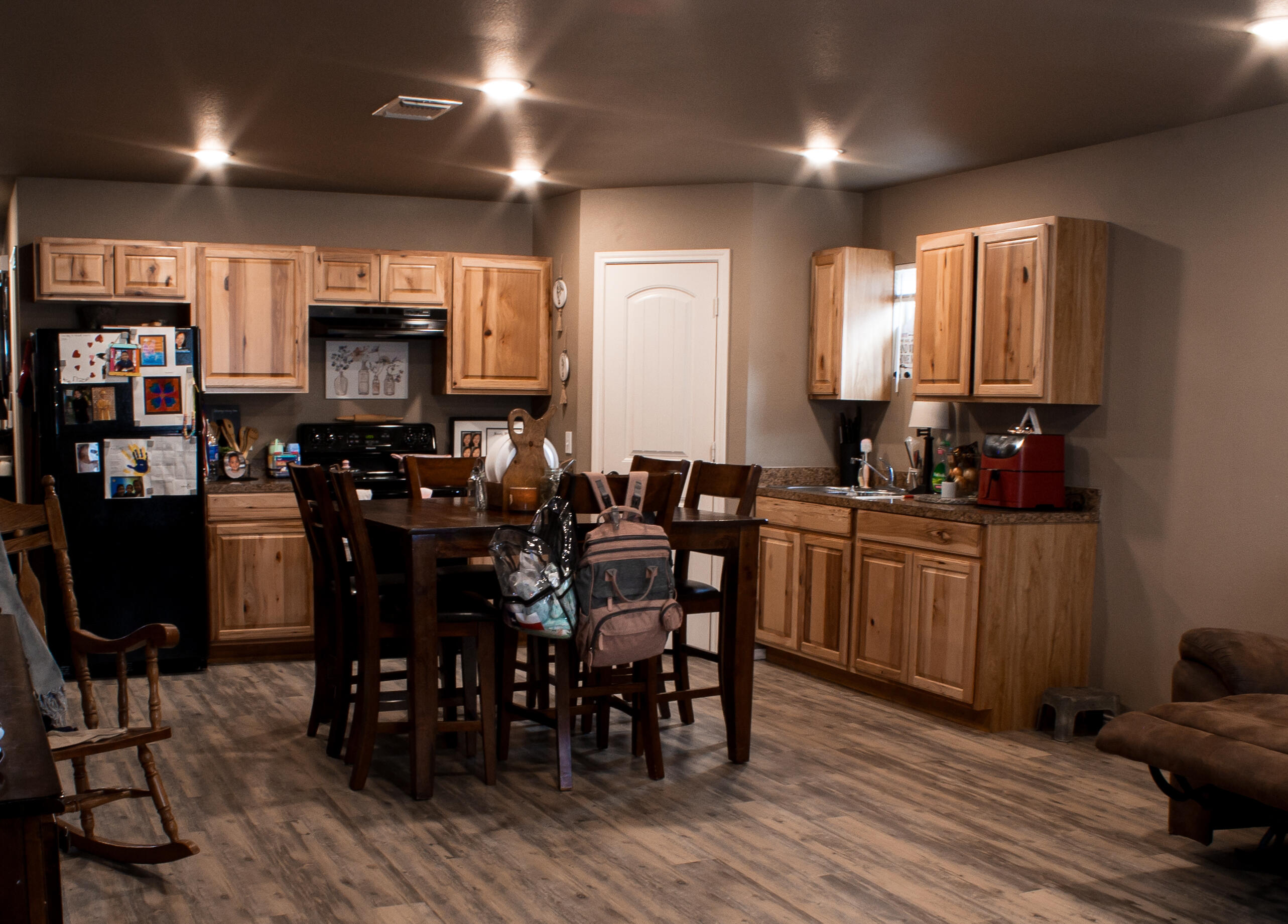211 42nd Street, Unit 2 Lubbock, TX 79404 - Photo 3 of 9 a kitchen with stainless steel appliances a dining table chairs and a refrigerator