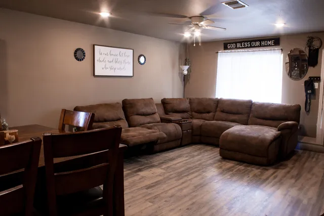 a living room with furniture a ceiling fan and a window