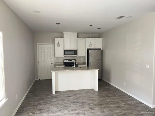 a kitchen with stainless steel appliances a refrigerator and a stove top oven
