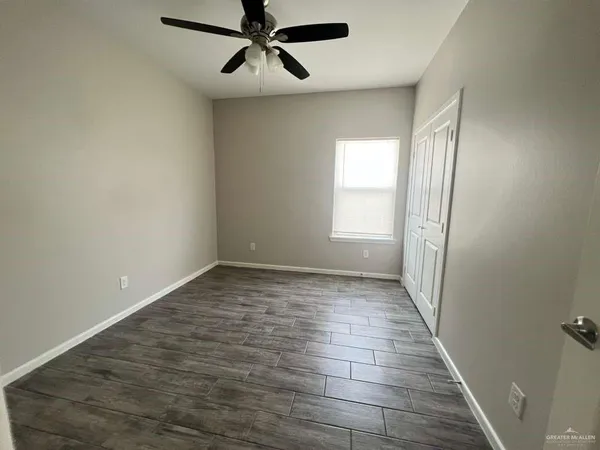 an empty room with windows and fan