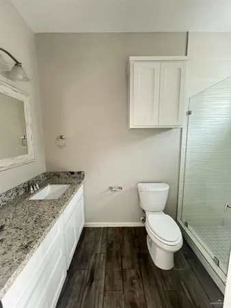 a bathroom with a granite countertop toilet and a sink
