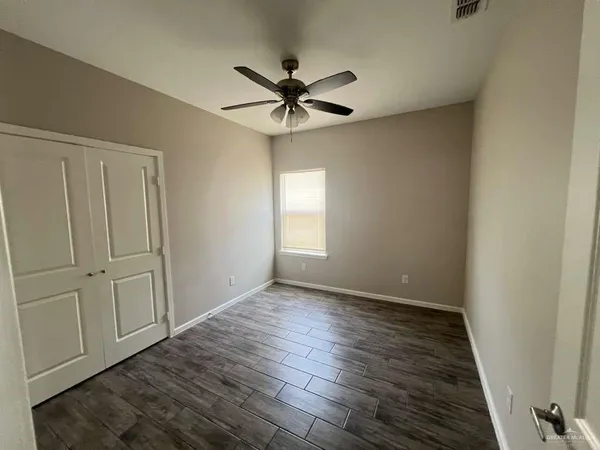a view of a livingroom with a window and wooden floor