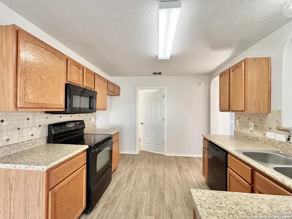 a kitchen with stainless steel appliances granite countertop a sink stove microwave and refrigerator