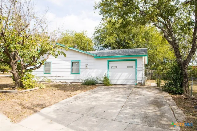 a backyard of a house with table and chairs
