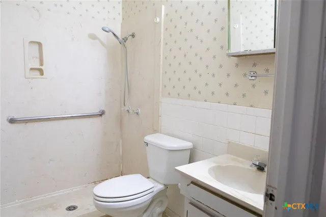 a white toilet sitting next to a bathroom sink