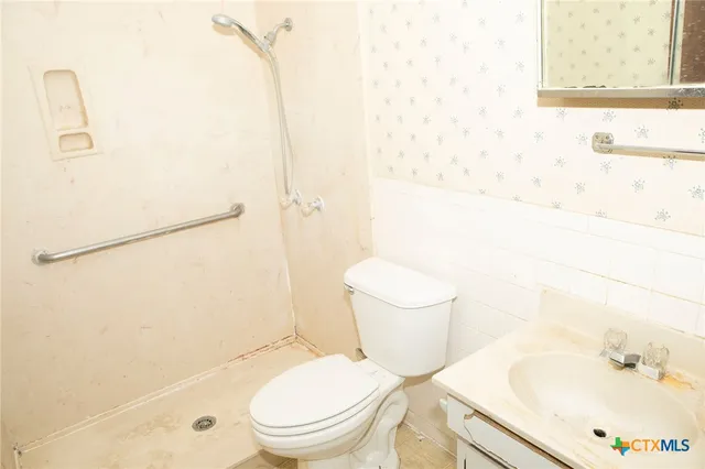 a white toilet sitting next to a bath tub