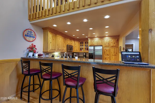 a view of a kitchen with lots of wooden furniture and windows